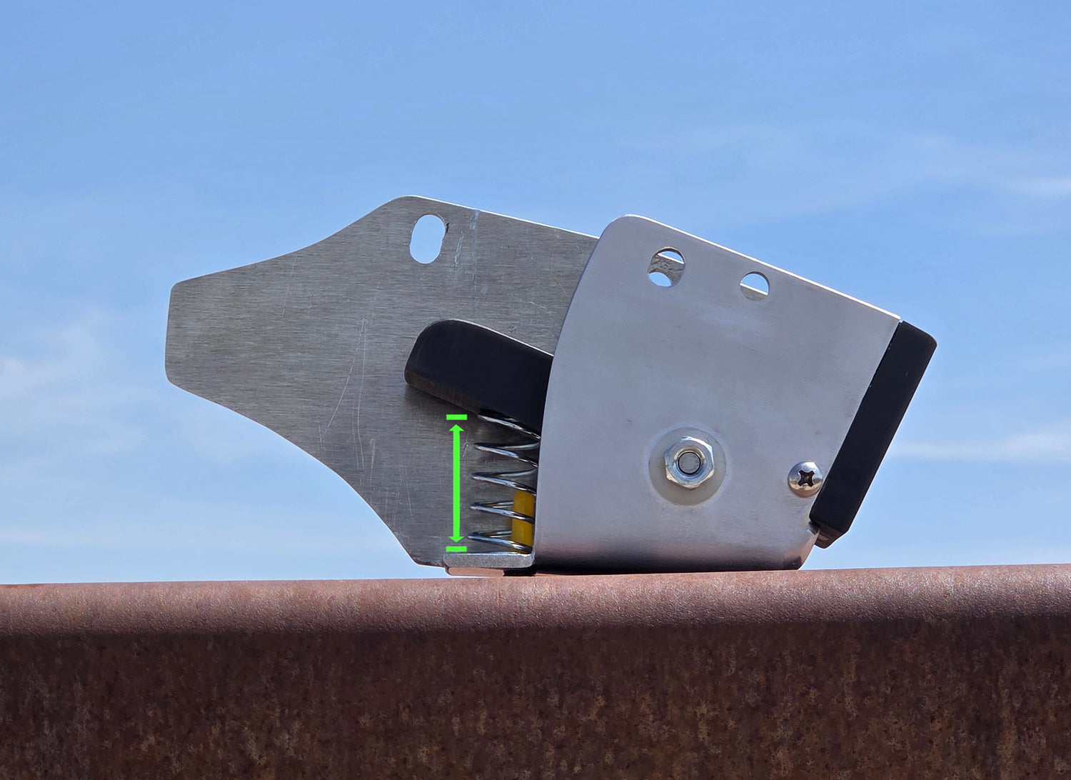 The CONETIC MOTO CO. Active Tension Chain Guard with a green arrow showing the travel of the spring and slide